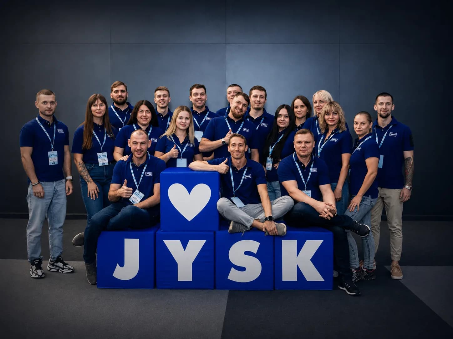 Команда JYSK на заході біля кубів, складених у назву бренду